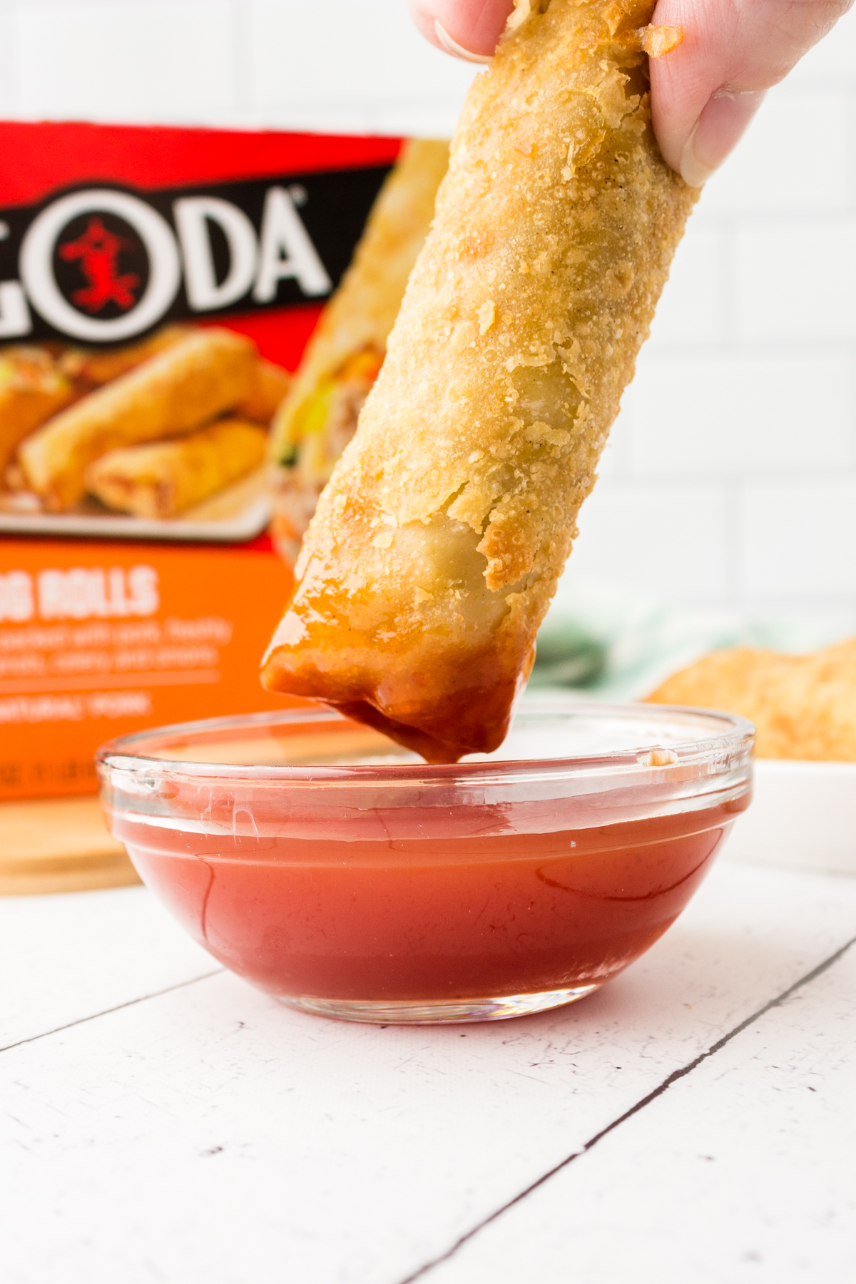 dipping pagoda egg rolls into sweet and sour sauce.

