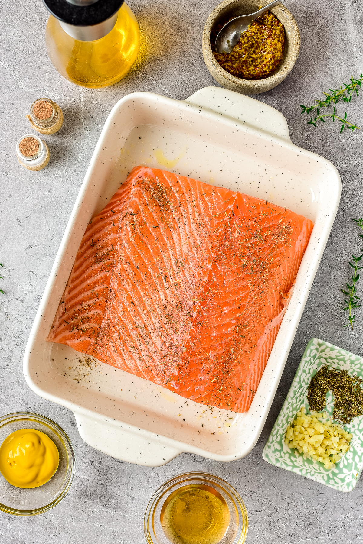 Seasoning the salmon with salt, pepper and thyme.