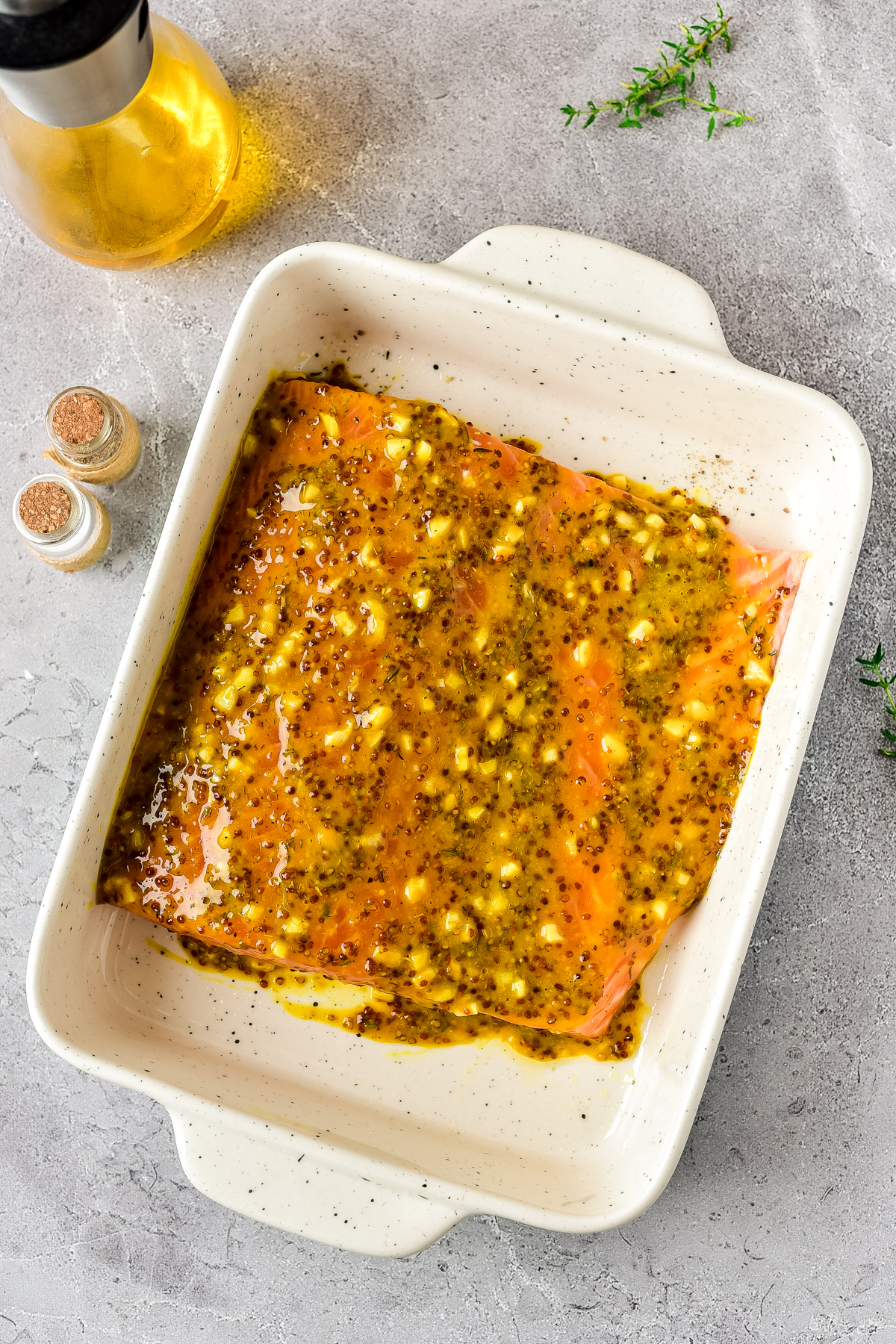 Spreading the mustard mixture over the salmon.